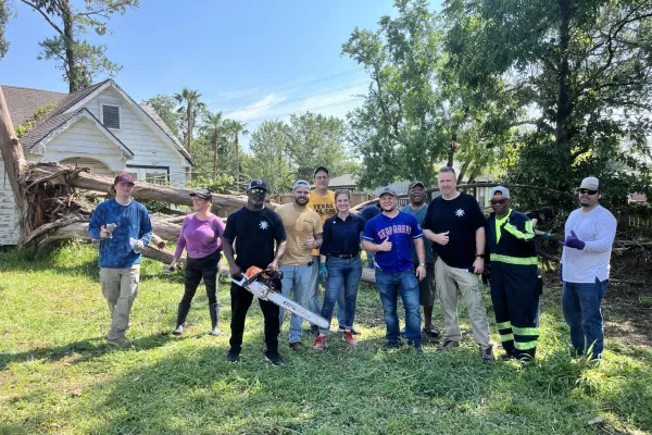 A group of union volunteers pose in front of a yard they cleared of debris from Hurricane Beryl.