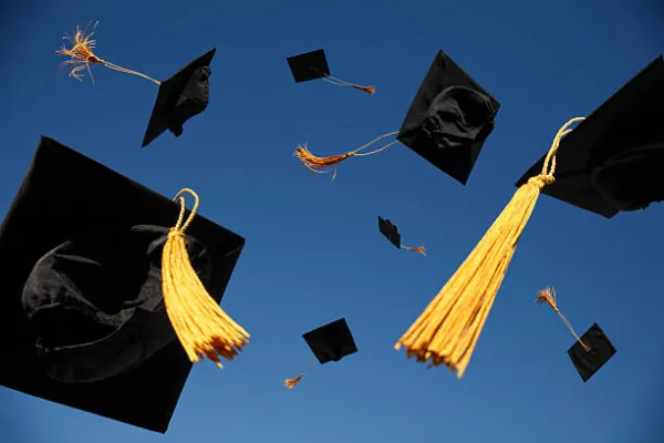 Graduation caps flying through the air.