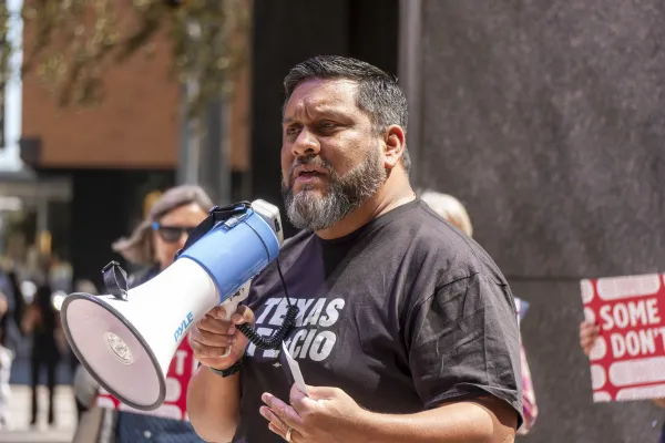 Leonard Aguilar speaks into a megaphone at a rally