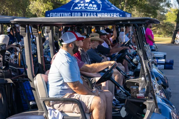 Golfers sit in their carts, waiting for the four person scramble to begin