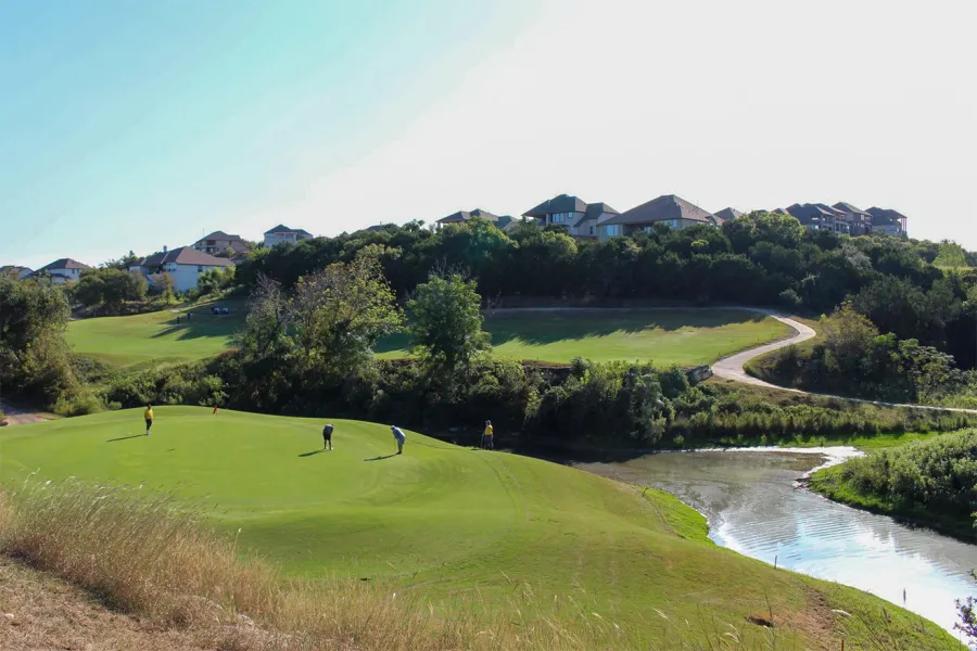 A golfers assesses their putt in a wide view of the Crystal Falls Golf Course