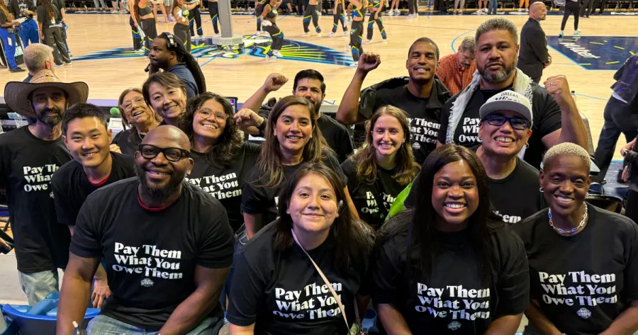 Labor Leaders at the Sept. 11 Dallas Wings game wearing "Pay Them What You Owe Them" t-shirts