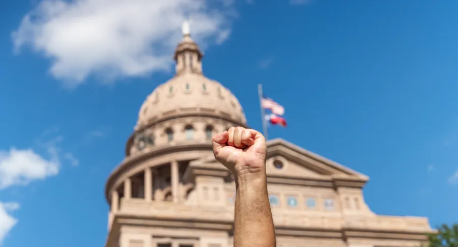A defiant fist is raised in front of the Texas Capitol
