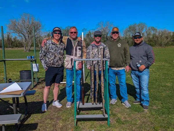 Union members pose for a photo outdoors before participating in a clays shoot.