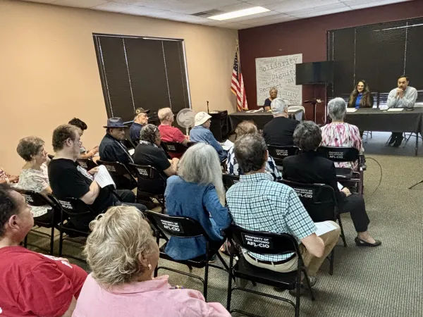 An audience at the Hank Brown Retirees’ Council San Antonio Save Our Seniors Round Table faces Liza Bazaldua-Miranda and Congressman Joaquin Castro (TX-20) who are seated at a table.