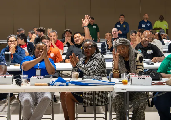 Houston Labor Town Hall attendees wave at the camera